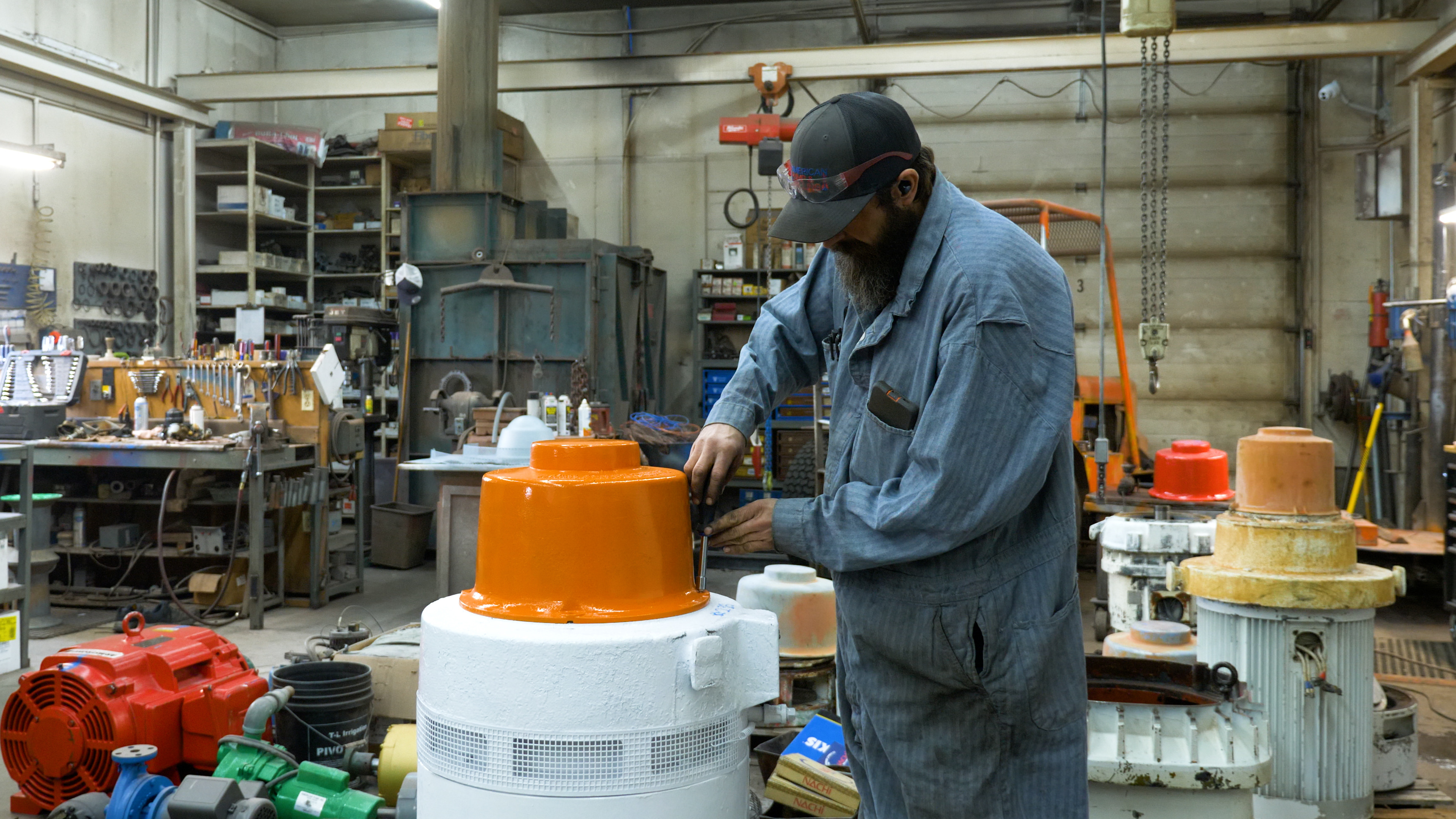 APD technician servicing an orange and white motor in the motor shop